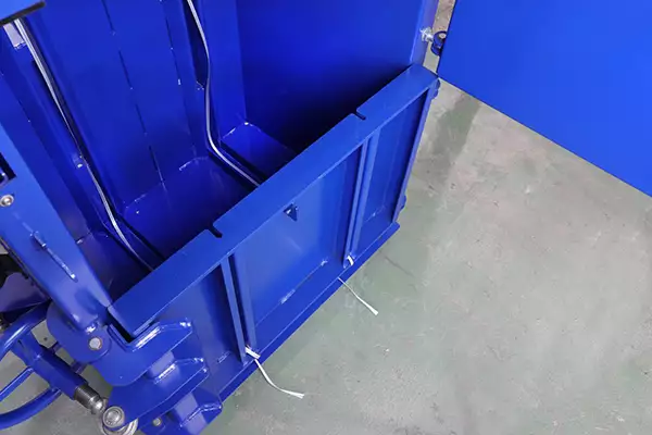Top down shot of the blue BP3CD mini baler. The door is ajar and the inside is empty.