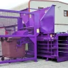 The CB44 baler in purple. A gate is attached and within the gate is a wheelie bin.