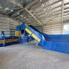 Wide shot of the CB-S Channel Baler positioned in the corner of a large warehouse.