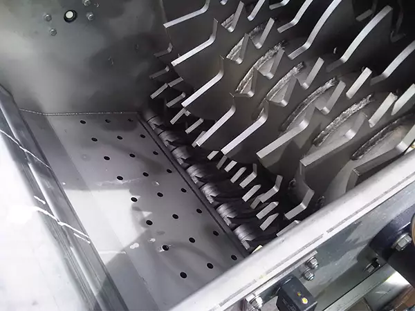 Inside of the LiquiDrainer Hand Feed shows a row of bladed wheels for emptying and compacting bottles and cans.