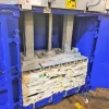 The doors of the MK1100 baler are open wide and inside can be seen compacted waste pushed down by the mechanism within.