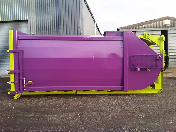 Side view of the purple and green RPK compactor standing outside. The bulk of the body is coloured purple and is bordered by a bright green frame.