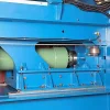 Close-up view of the green hydraulic cylinder in the blue Twin Ram Baler.