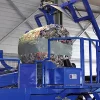 Close-up on the Flexus Balasystem in blue. A large ball of compacted trash sits atop the machine, wrapped in a strip of grey plastic.
